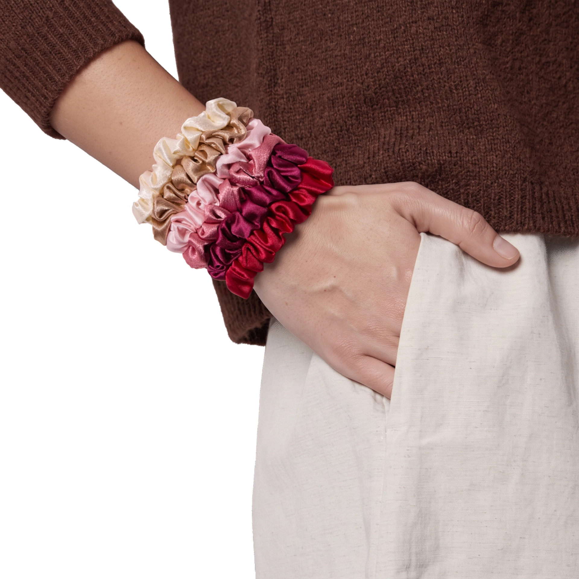 Summer & Rose set of six satin scrunchies in cream, tan, light pink, rose, burgundy, and red, stacked on a model's wrist against a white background.