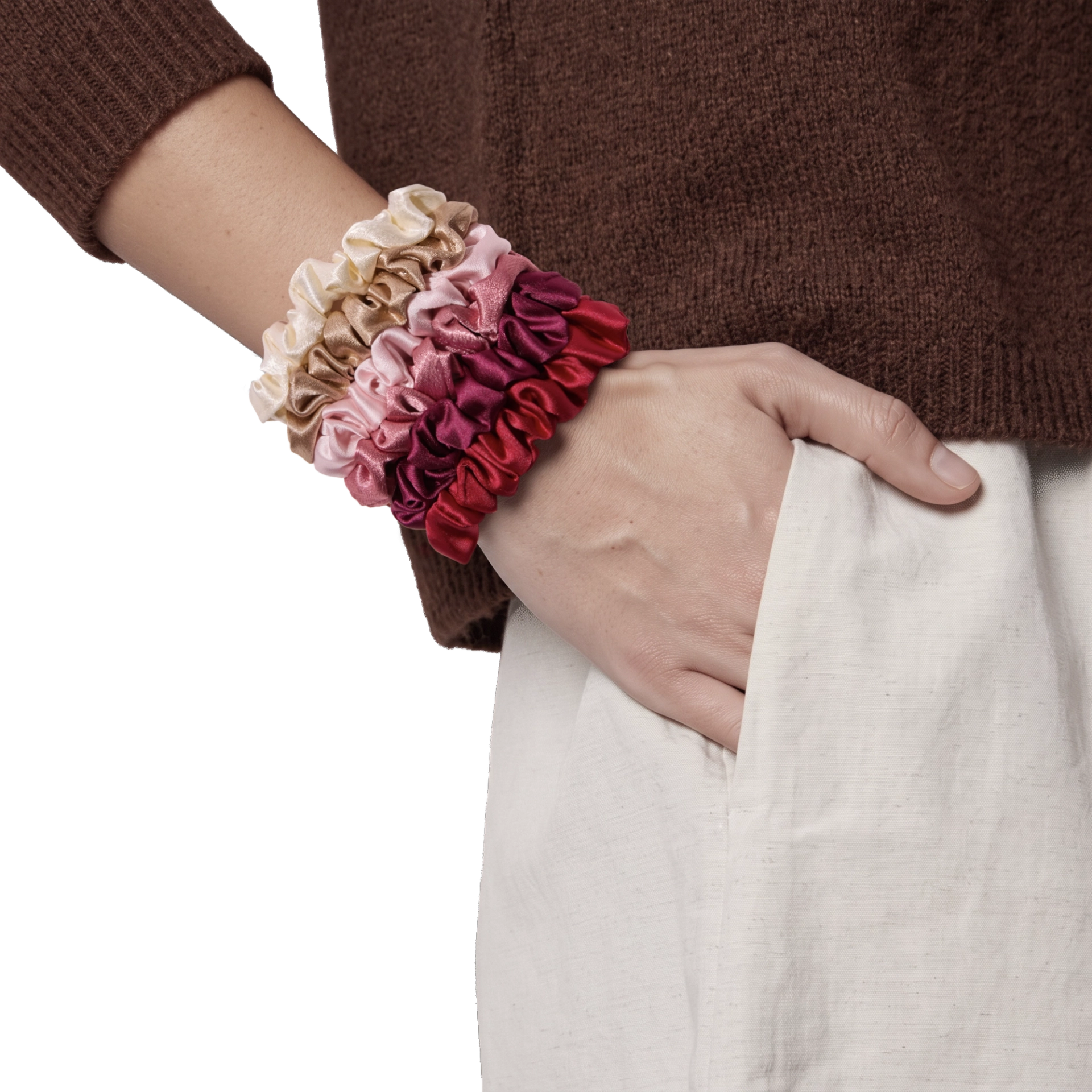 Summer & Rose set of six satin scrunchies in cream, tan, light pink, rose, burgundy, and red, stacked on a model's wrist against a white background.
